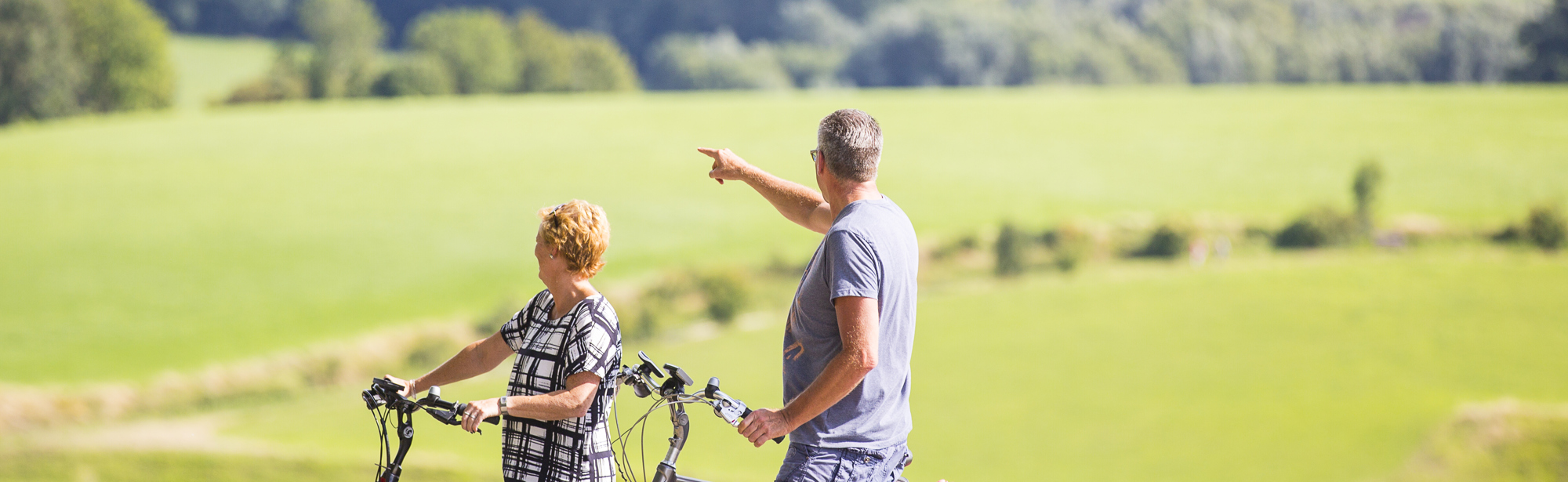 Een man wijst naar iets in de verte en zijn vrouw kijkt ernaar