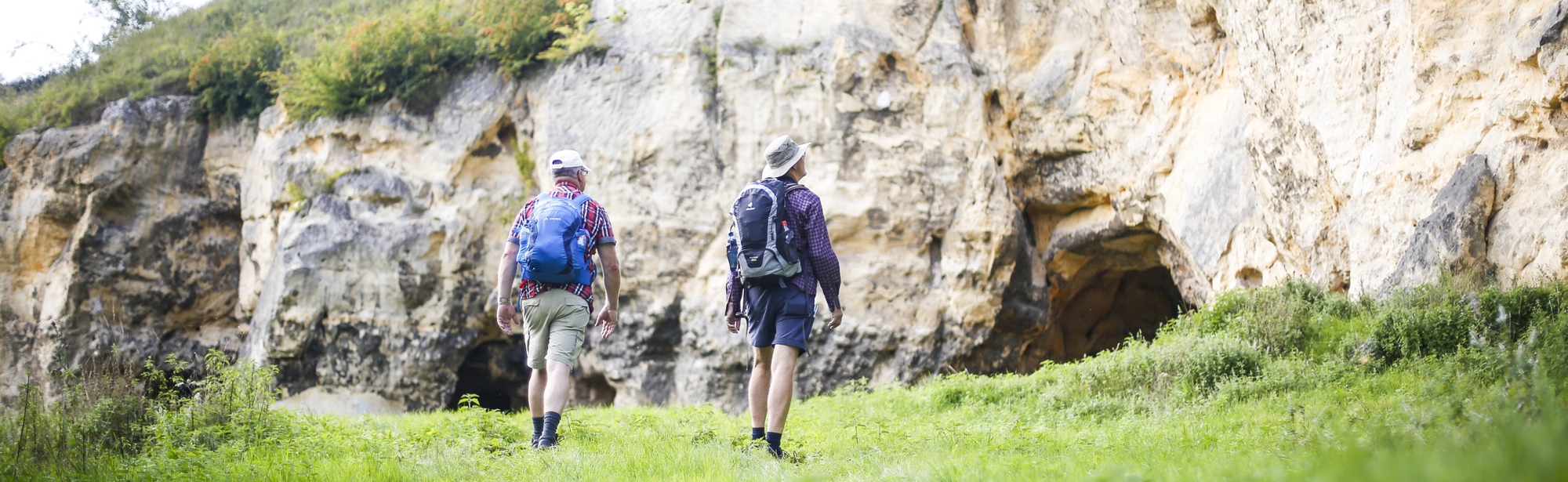 Twee mannen lopen langs een indrukwekkende krijtwand