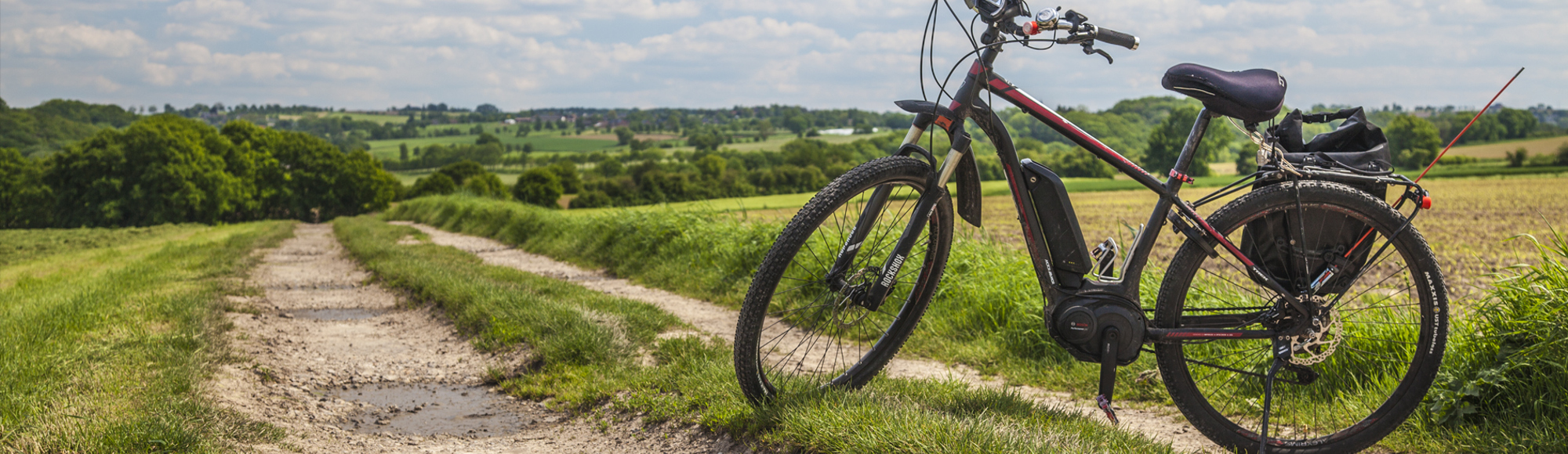 Een rode mountainbike staat geparkeerd in het heuvellandschap 